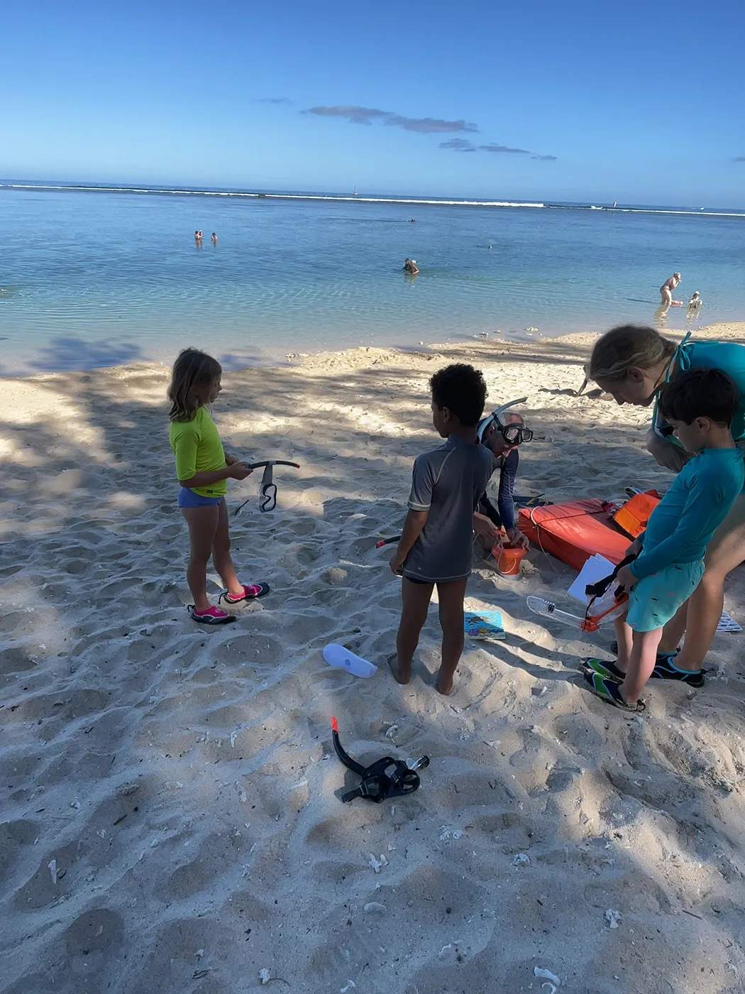 Groupe d’enfants rassemblés sur la plage avec le matériel de dessin après l’activité en mer