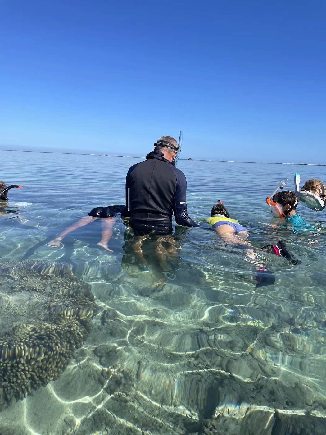 Encadrant guidant des participants lors d’une séance de dessin sous-marin en eau peu profonde